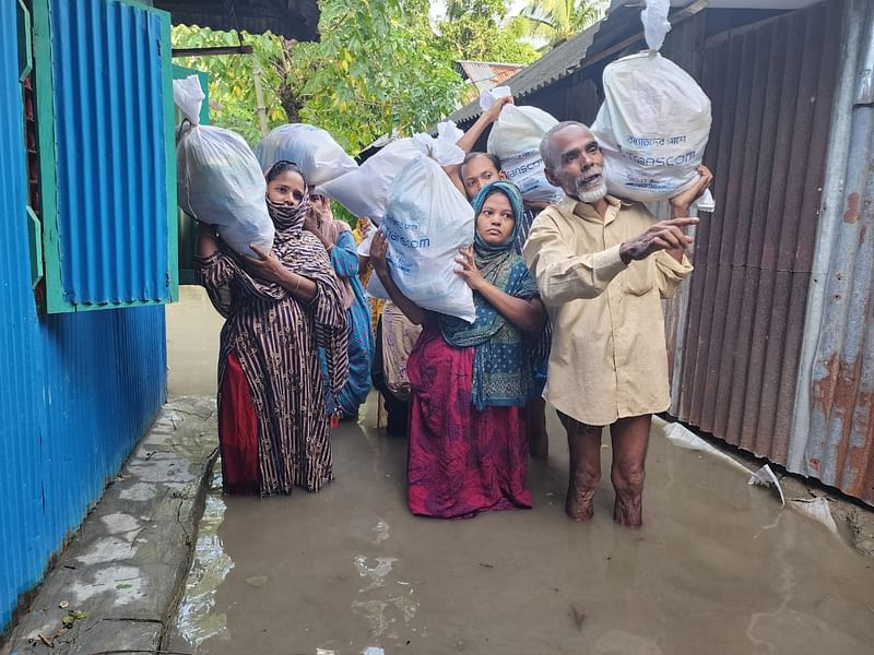 ট্রান্সকম গ্রুপের পক্ষ থেকে দেওয়া ত্রাণসামগ্রী হাতে কয়েকজন